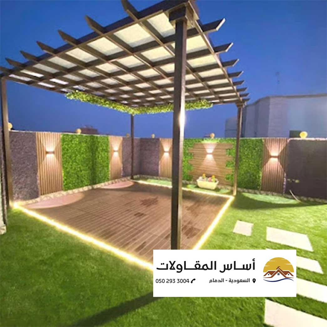 الرئيسية صورة توضح تصميم ركن خارجي مع إضاءة ليلية بواسطة شركة أساس المقاولات، حيث يظهر السقف المبتكر والأرضية الخشبية.