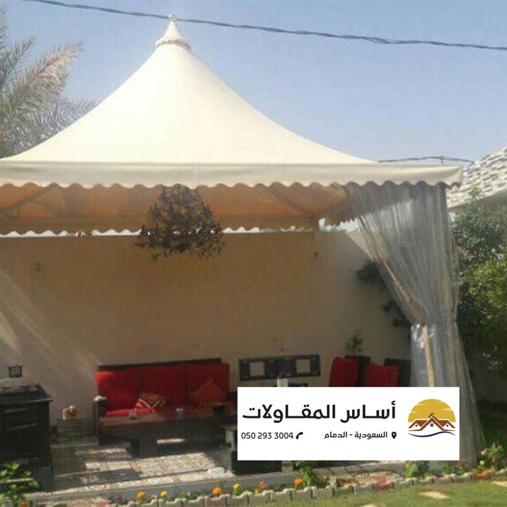 مظلات وسواتر صورة توضح تصميم ركن خارجي مريح بواسطة شركة أساس المقاولات، حيث يظهر الأثاث المريح والخيمة الأنيقة.