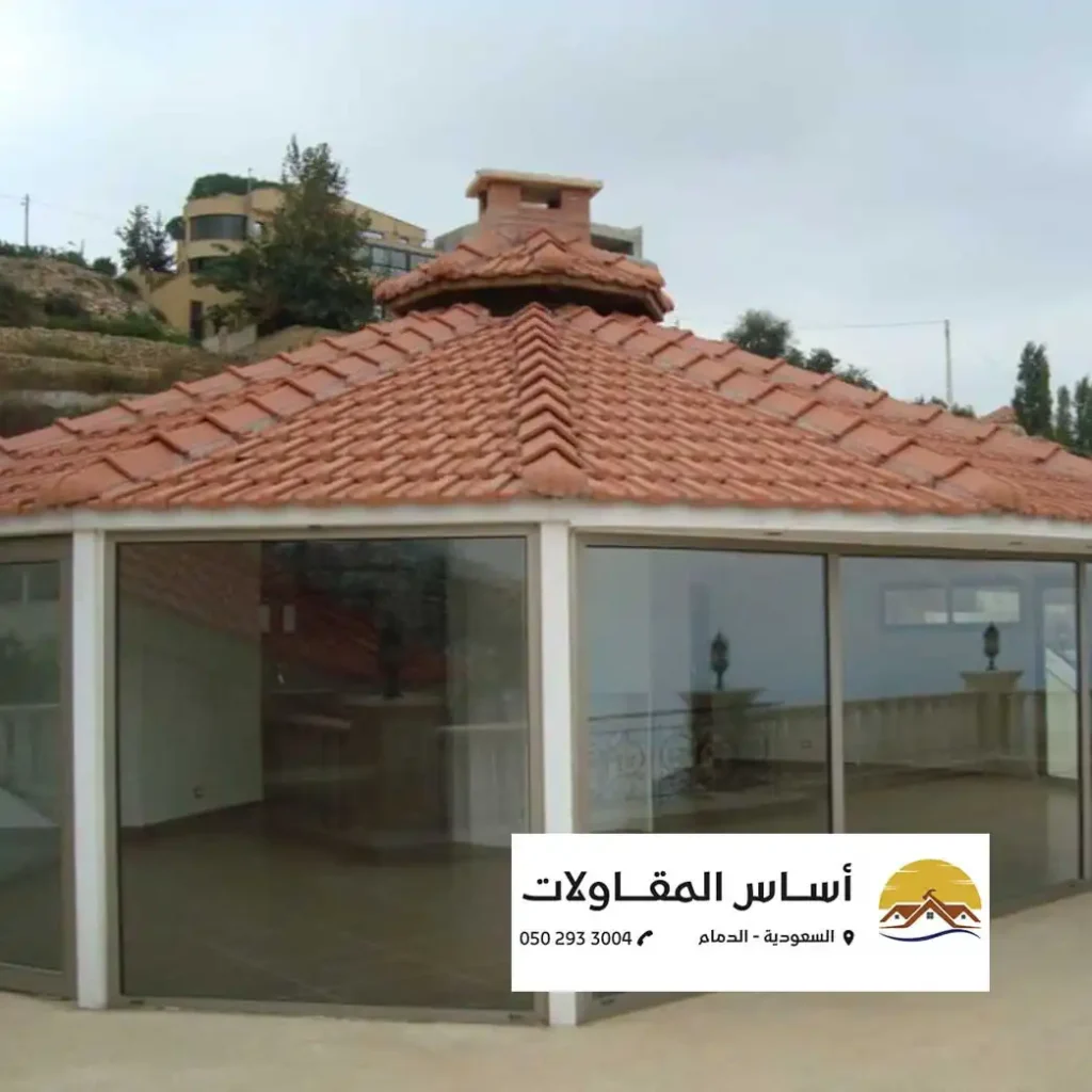 الرئيسية صورة تصميم داخلي لمشروع تابع لشركة أساس المقاولات، مع نوافذ كبيرة وسقف مميز. يظهر في الأسفل معلومات الاتصال بالشركة.